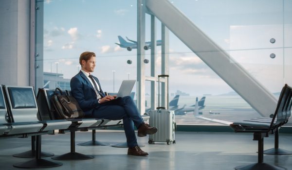 Modern,Airport,Terminal:,Handsome,Businessman,Working,On,Laptop,Computer,While